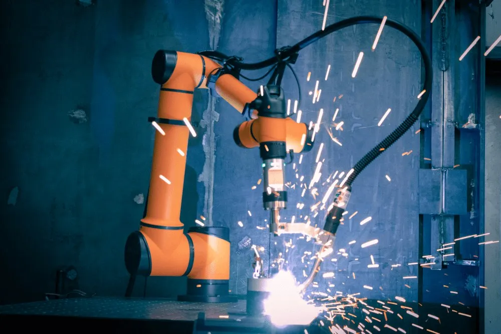 A collaborative robot welding, with sparks flying from the torch