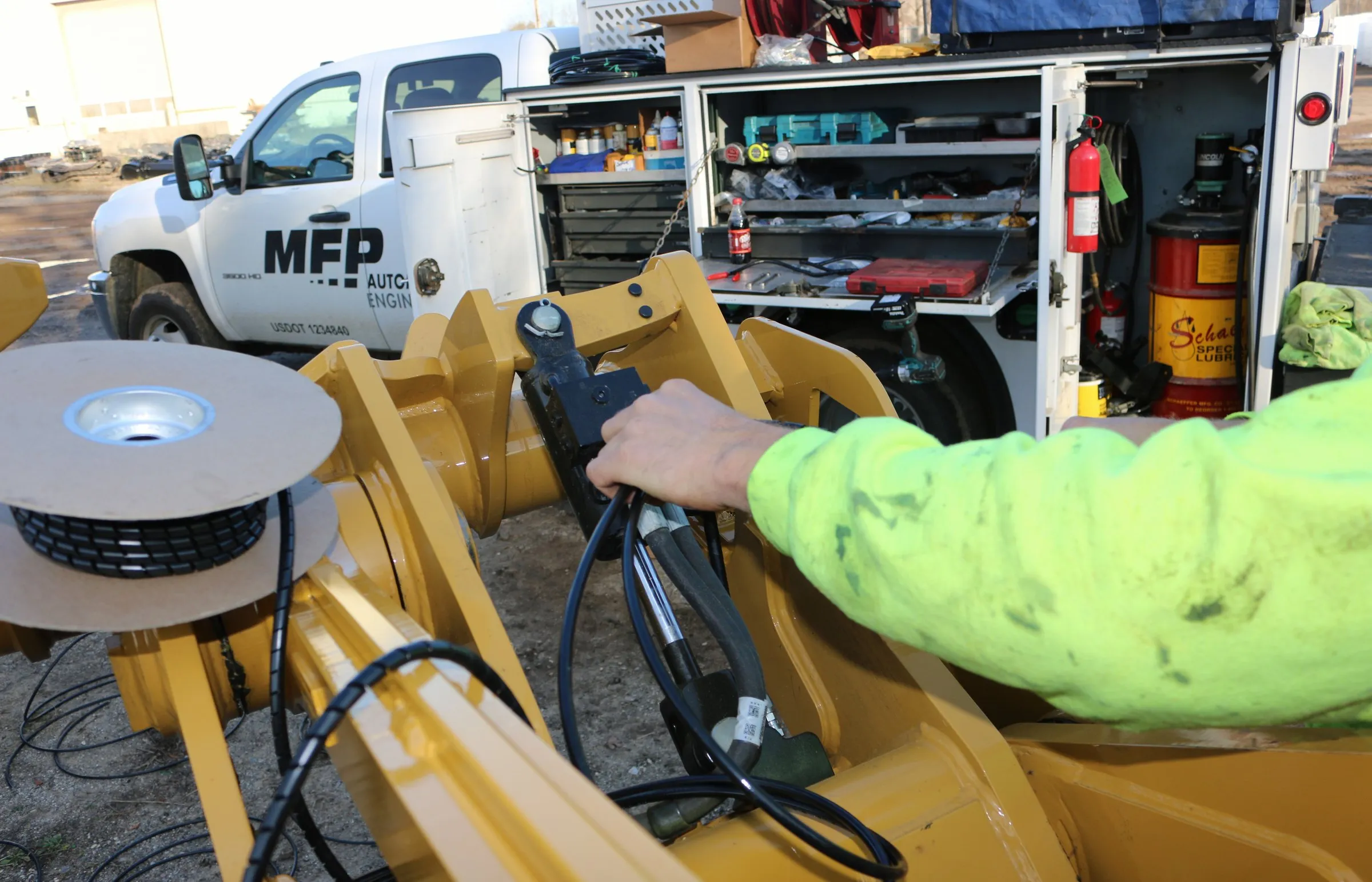 Hydraulic coupler handle beside an MFP Automation Engineering service truck