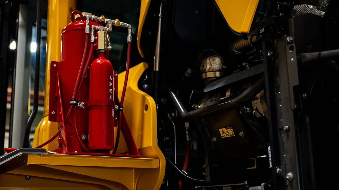 Red AFEX fire suppression tank mounted on the back of a yellow wheel loader