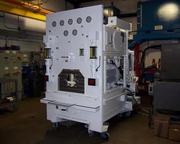 Gray gauge panel unit with several pressure gauges and access doors on casters, in a dimly lit shop