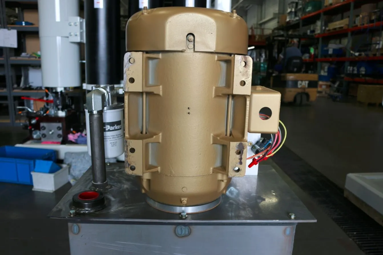 Close-up of a gold-painted motor mounted on a hydraulic reservoir, with a Parker filter canister beside it