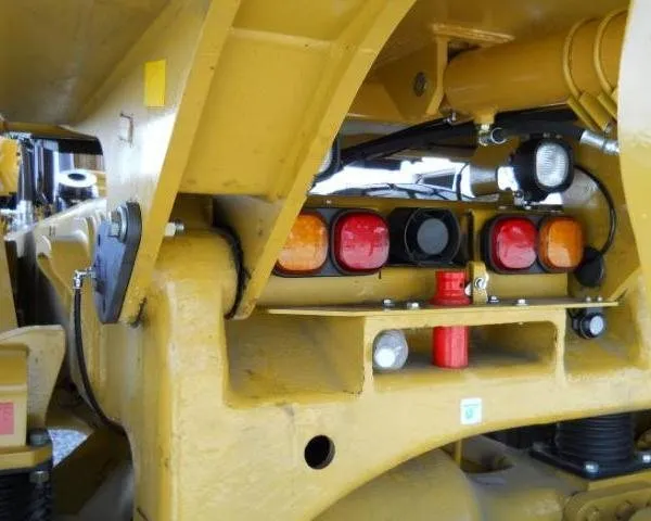 Grease lines routed past the taillight cluster on the rear frame of a haul truck