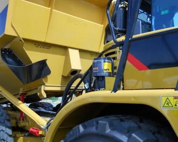 Automatic grease pump reservoir mounted on the body of an off-road haul truck