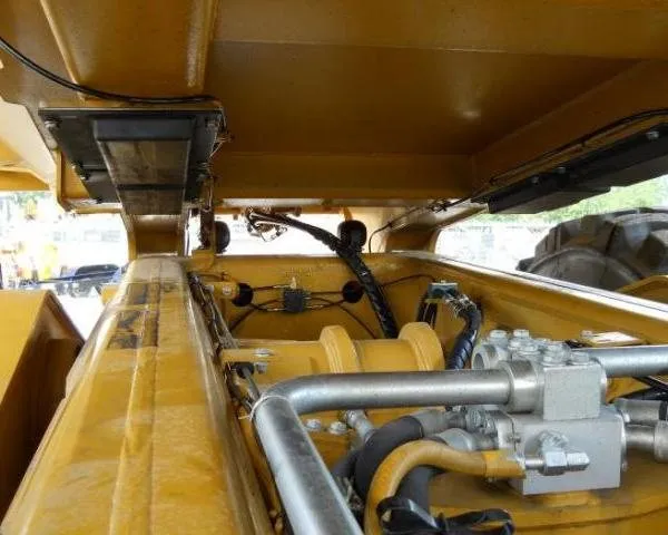 Hydraulic manifold, hoses and wiring mounted in the engine bay area of a haul truck