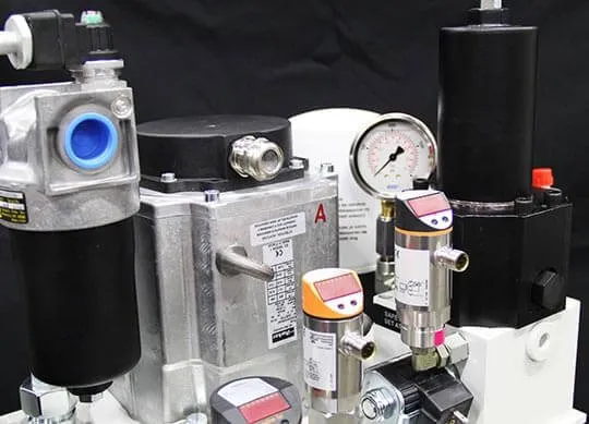 Studio photo of a hydraulic manifold assembly with filter, gauge, and pressure switches