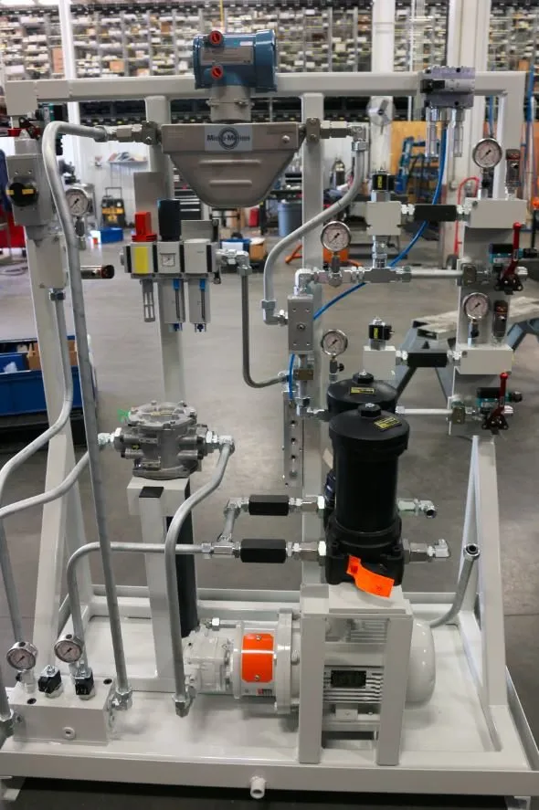 Hydraulic power unit skid with gauges, filters and a Micro-Motion flow meter in a warehouse aisle