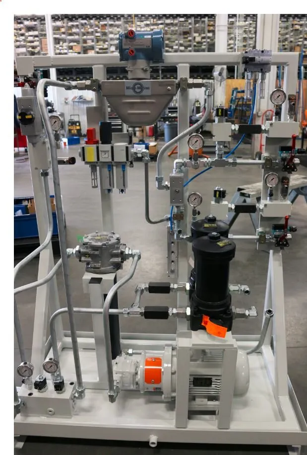 Hydraulic power unit skid with a Micro-Motion flow meter, filters and pressure gauges in a warehouse