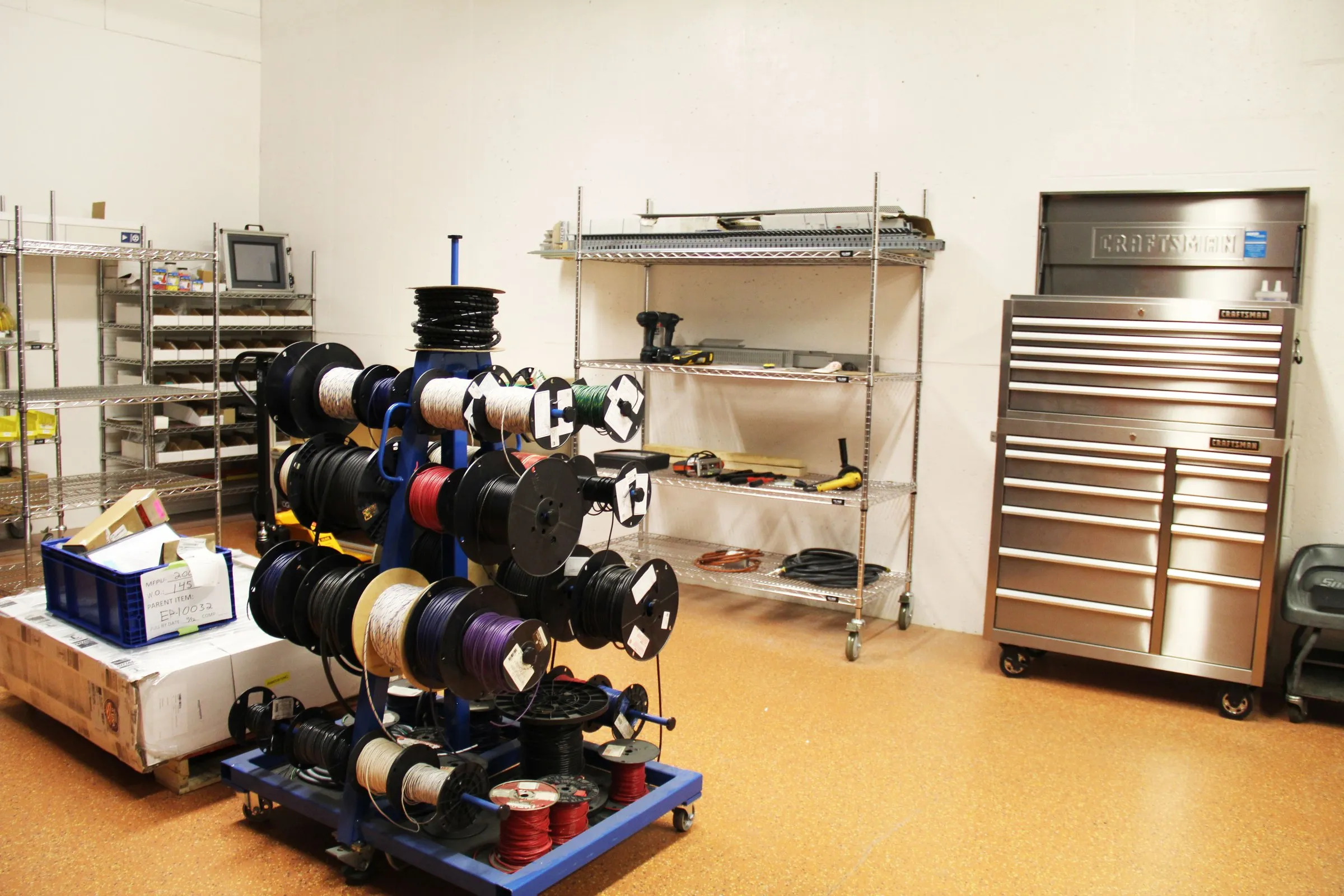 Panel assembly room with a wire spool rack, shelving and stainless tool chests