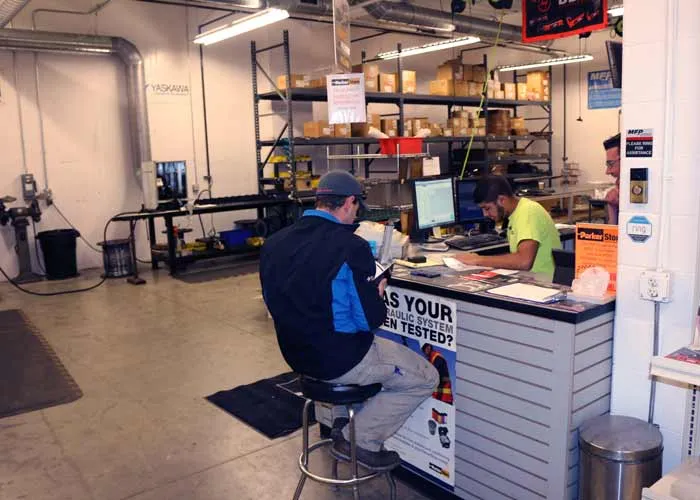 ParkerStore staff looking up a hydraulic part for two customers at the sales counter in Hudsonville, Michigan.