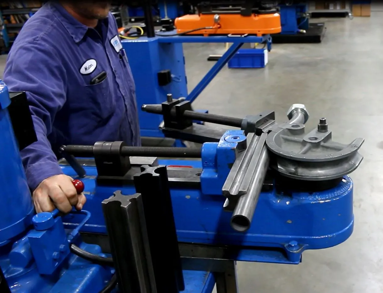 MFP technician bending steel tube on a hydraulic tube bender